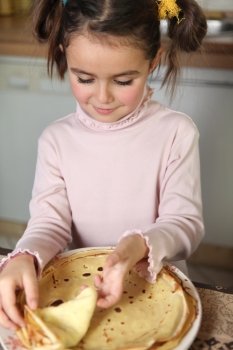 Little girl preparing pancakes