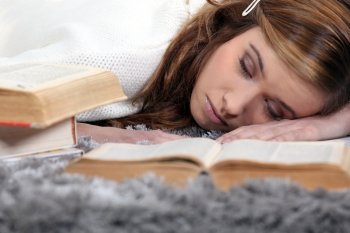 Female teenager asleep on a book