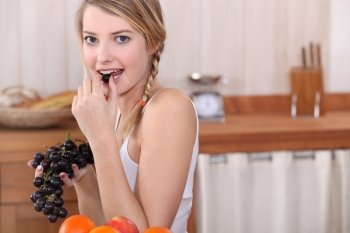 Blonde woman eating grapes