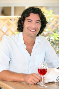 Smiling man enjoying a glass of rose
