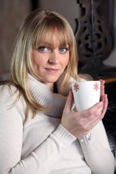 Young woman with a hot drink at home