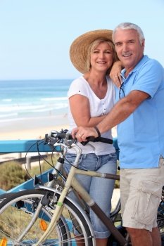 Mature couple with bikes by a beach
