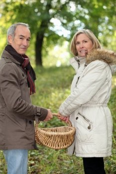 Couple walking through field with basket