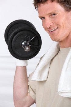 Smiling man lifting barbell on white background