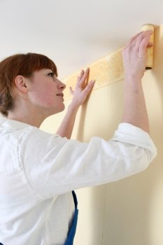 Woman putting up a wallpaper border
