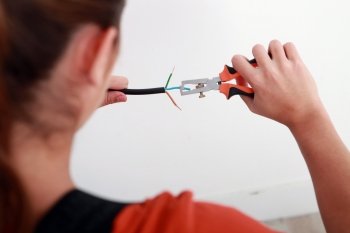 A female electrician stripping a wire.