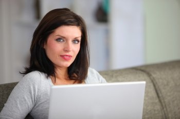 Woman with computer sitting on sofa