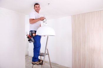 Handyman fixing ceiling light