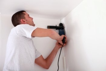 Man drilling a ceiling