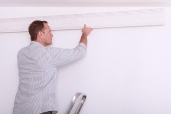 man installing a protection on a wall