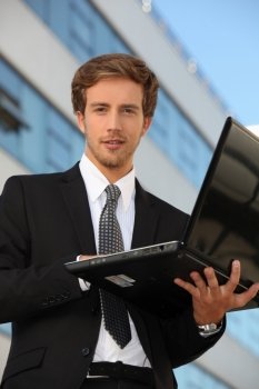 Man in suit carrying a laptop