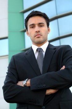 Confident young businessman stood outside office