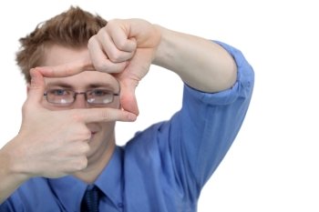 Young man using his fingers to frame his glasses