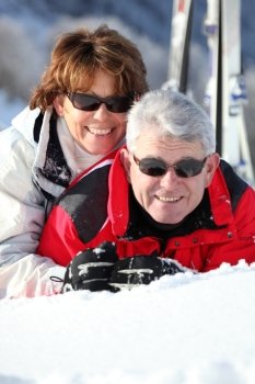 Middle-aged couple having fun on their skiing holiday