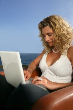 Woman using a laptop by the sea