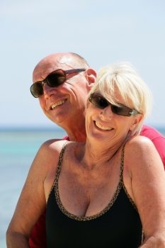 Senior couple stood on a secluded beach