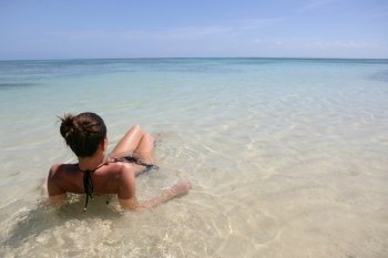 Woman laying in shallow sea water