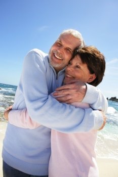 Older couple hugging on a beach