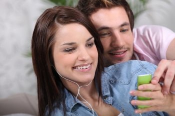 Young couple with a personal music player