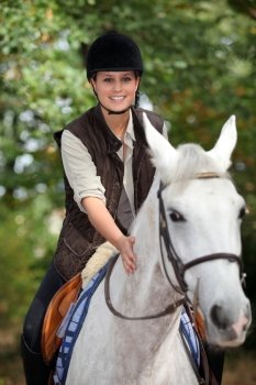 young horsewoman with white horse