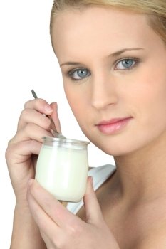 Young woman eating a yogurt