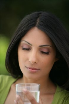 Indian woman drinking a glass of water