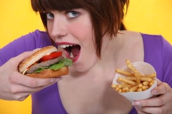 Woman eating a burger and chips