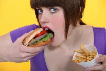 woman eating hamburger and French fries