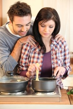 Young married couple cooking dinner