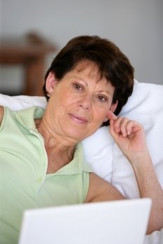 senior woman relaxing on the couch with her laptop