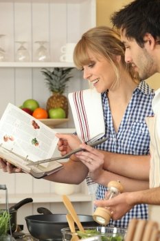 Young couple using a cookbook