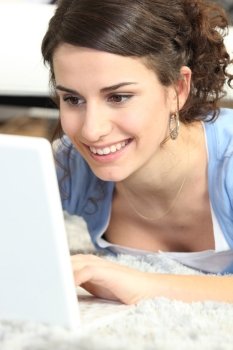 Woman laid typing on laptop