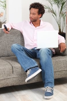 Man at home with a laptop and phone