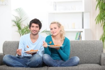 Couple having dinner on their couch