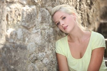 Woman posing against stone wall
