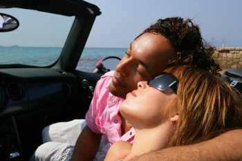 Couple relaxing in a convertible car