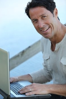 Man sat outdoors with laptop