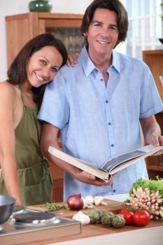 Couple in kitchen with cookbook