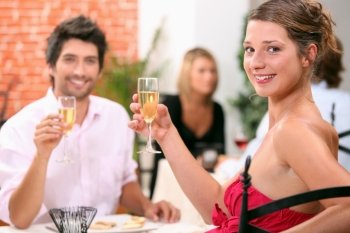 Man and woman holding champagne glasses in restaurant