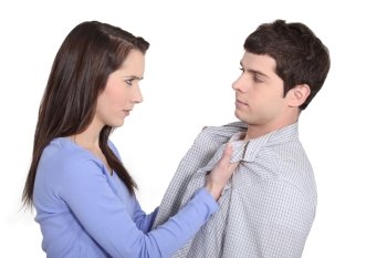 Young woman grabbing a man by his lapels