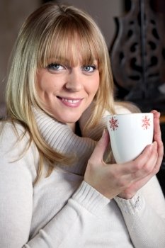 Portrait of a blonde woman drinking a hot drink