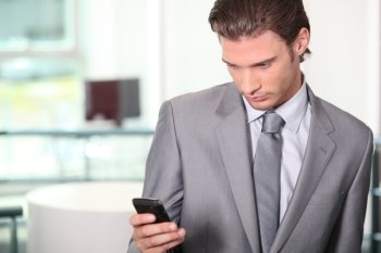 Male executive checking messages on cellphone