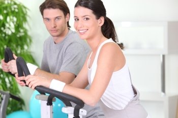 Young couple using gym equipment