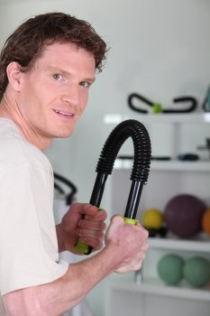 ginger young man bodybuilding with spring device