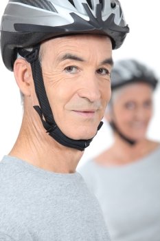 old man and his partner wearing bike helmets