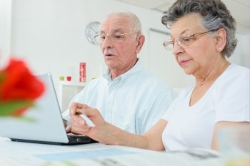 Elderly couple on computer, wife holding credit card