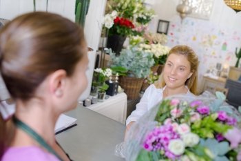 Handing a customer her flowers