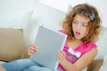 Surprised child looking at tablet