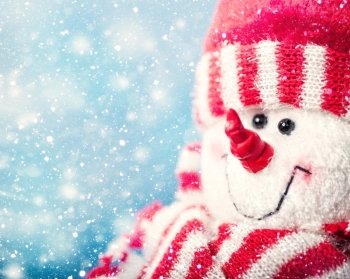Funny snowman portrait against snowfall, abstract christmas backgrounds