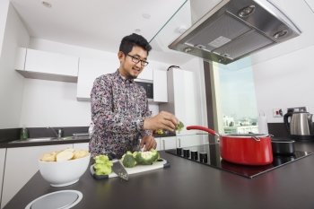 Smiling man cooking in kitchen at home